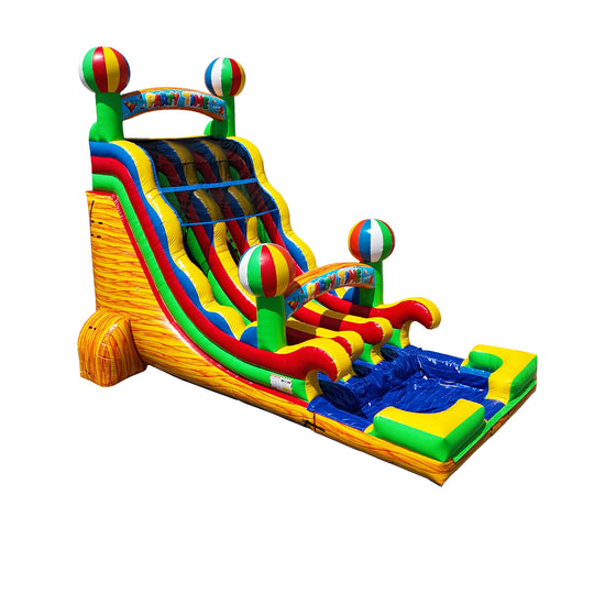Colorful double water slide with red, green, and yellow accents, featuring beach ball decorations and a splash pool at the