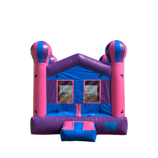 Bright pink and blue commercial bounce house for sale featuring tall striped towers and mesh windows.
