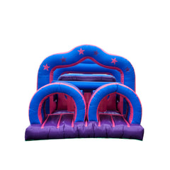 Colorful pink and blue commercial obstacle course inflatable featuring tunnels and slides, set against a white background.